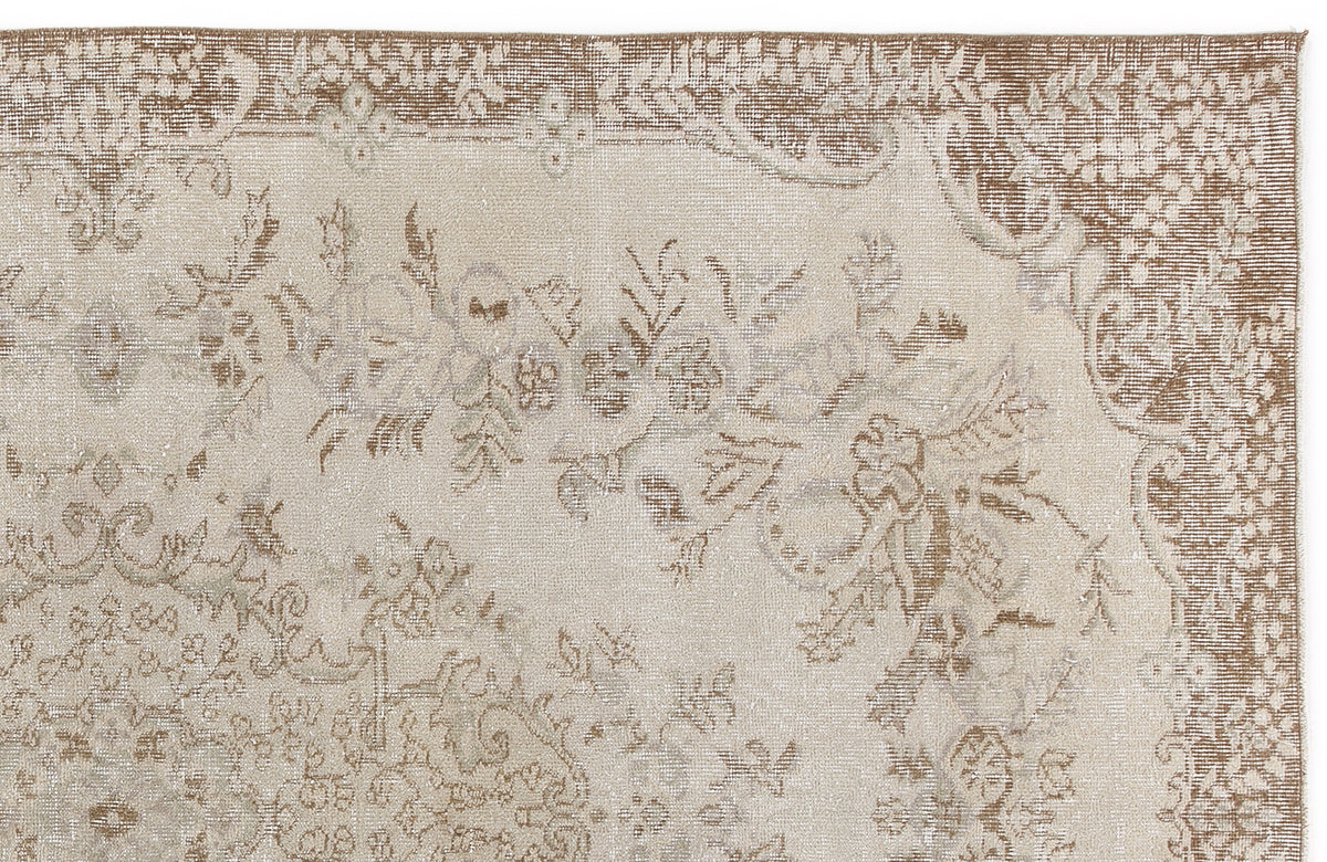 Beige and taupe traditional rug with a distressed floral medallion pattern on a white background.
