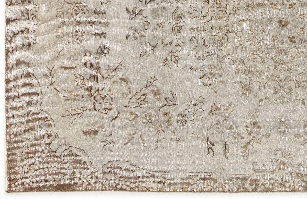 Beige and taupe distressed rug with a traditional floral medallion pattern and ornate border.