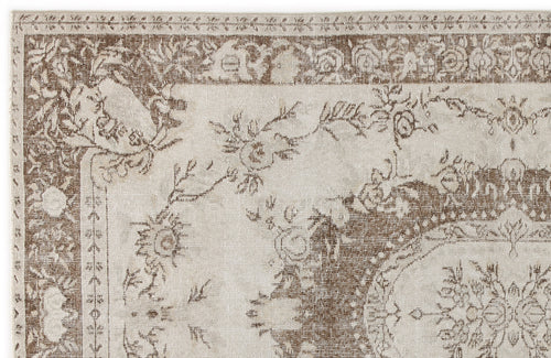 Load image 1 in gallery view. Beige and brown distressed rug with a traditional floral medallion pattern and ornate border.