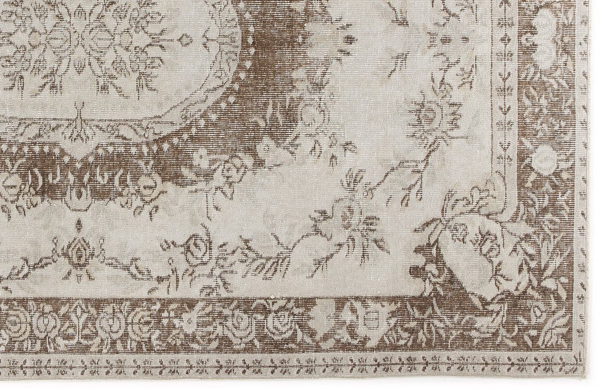 Taupe and cream traditional rug with a distressed floral medallion pattern and ornate border.