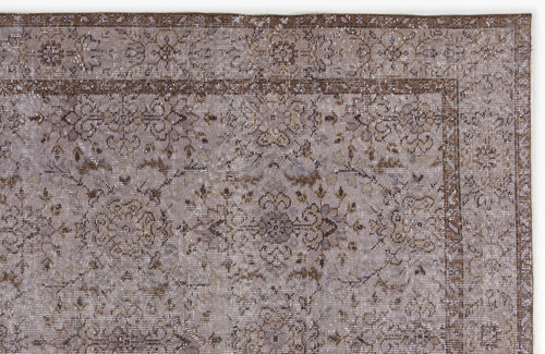 Load image 1 in gallery view. Distressed taupe and brown rug with a traditional floral medallion pattern and a detailed geometric border.