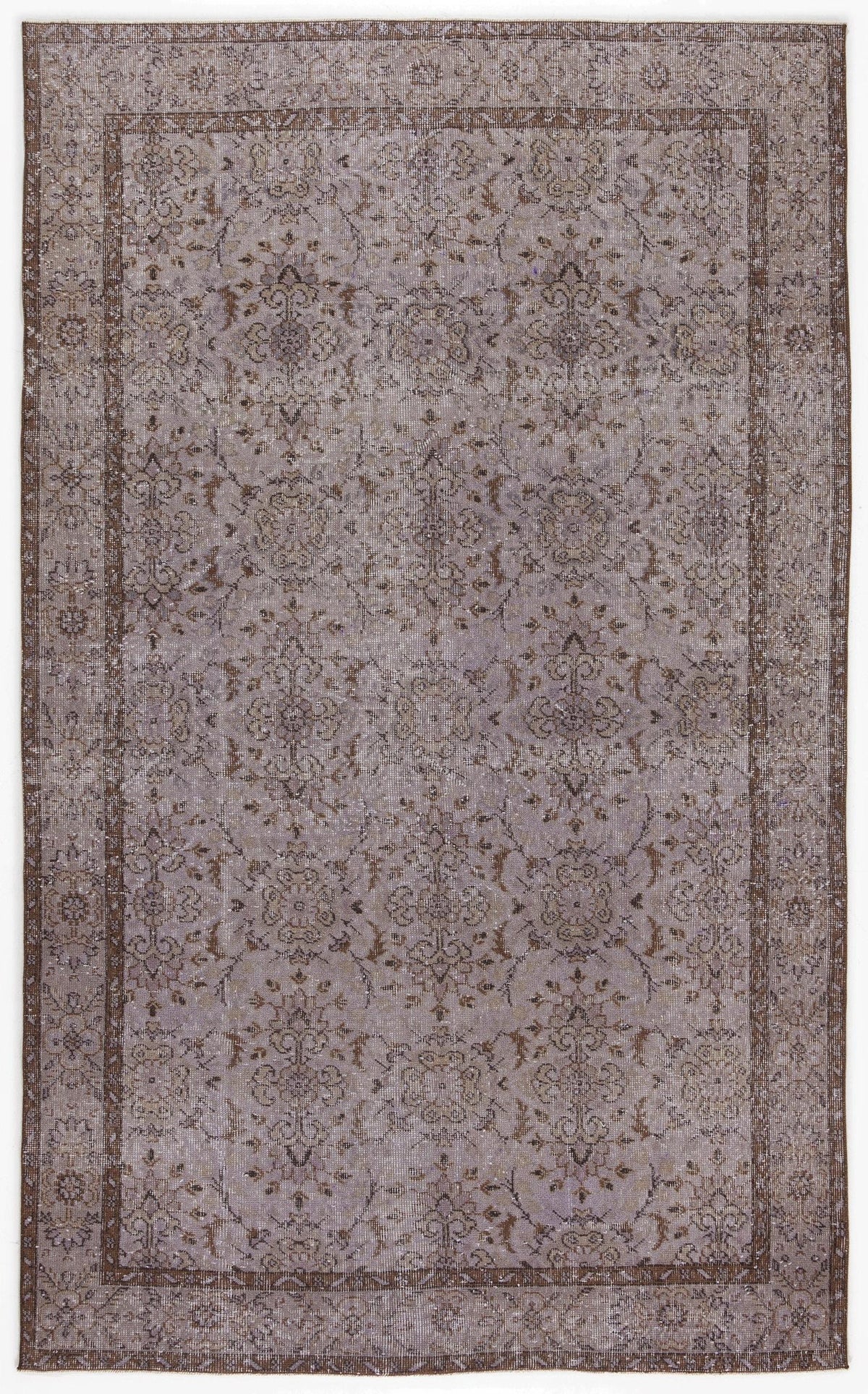 Distressed lavender and brown rug with a traditional floral medallion pattern and a wide decorative border.