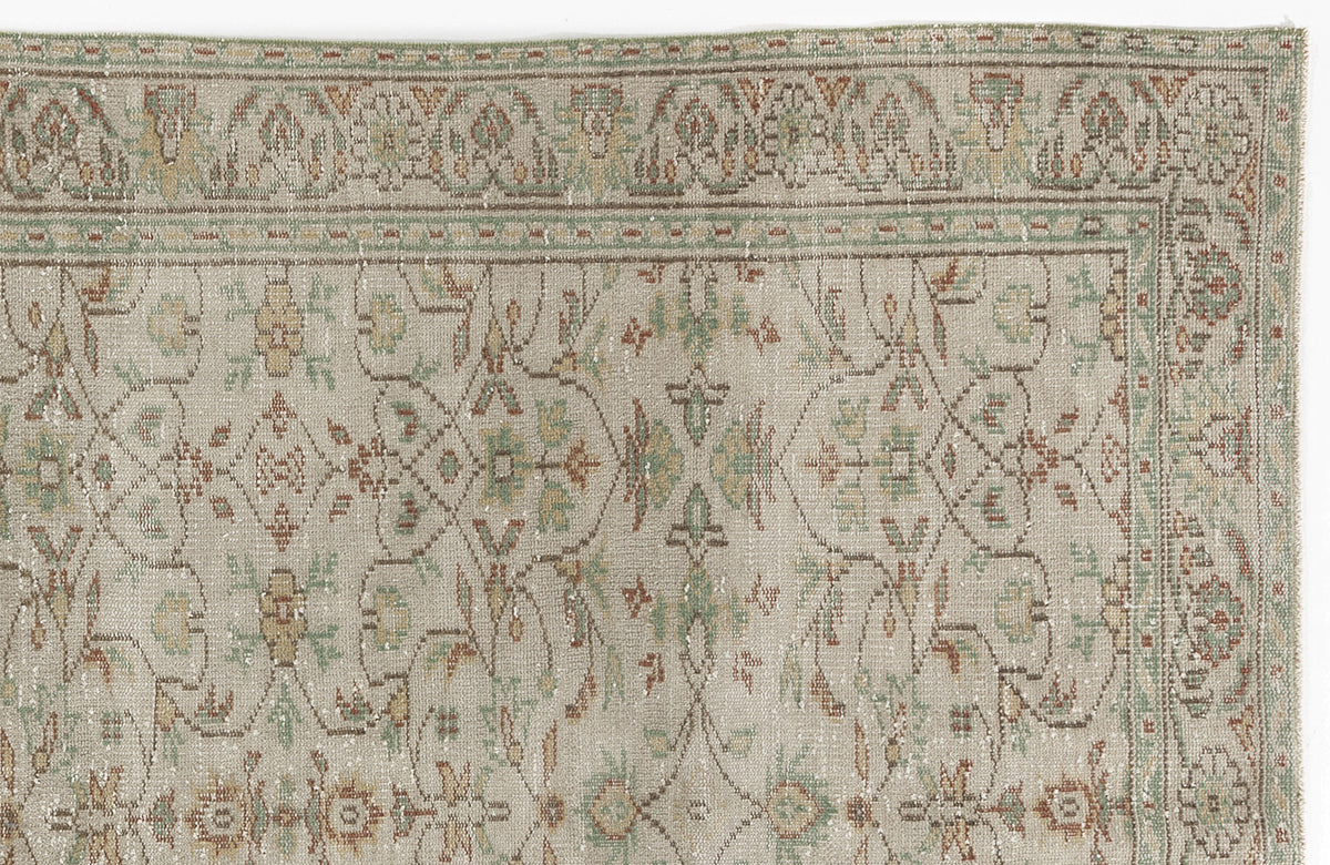 Beige rug with a distressed traditional floral pattern in muted sage green, terracotta, and gold.
