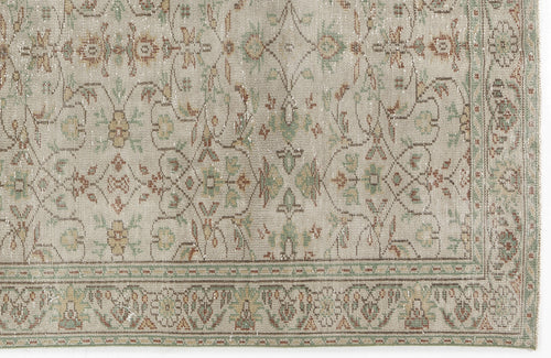Load image 1 in gallery view. Beige rug with a distressed traditional floral medallion pattern in muted green, rust, and gold tones.
