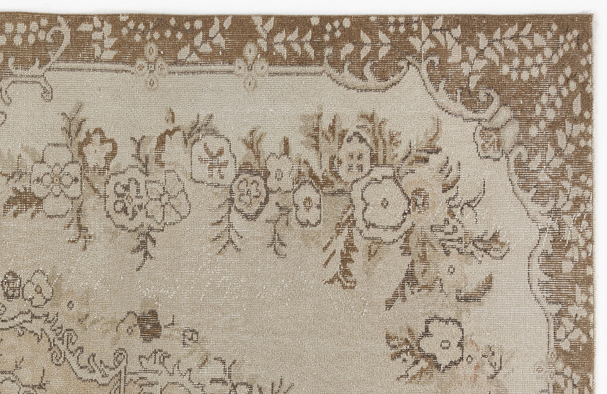 Beige and brown rug with a distressed floral medallion pattern and a decorative border.