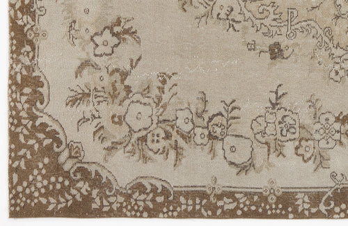 Load image 1 in gallery view. Beige and brown vintage-style rug with a distressed floral medallion pattern and decorative border.