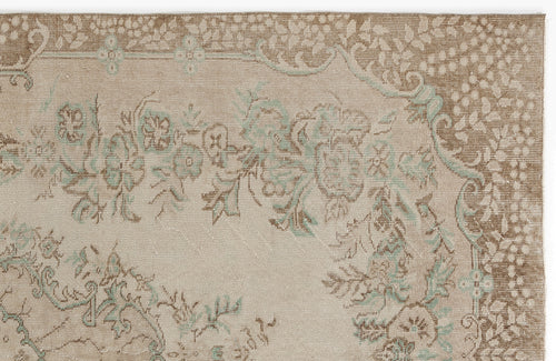 Load image 1 in gallery view. Beige and brown traditional rug with a faded floral medallion pattern and soft teal accents.