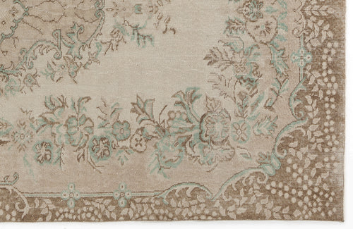 Load image 1 in gallery view. Beige and brown rug with a faded floral medallion pattern and soft teal accents.