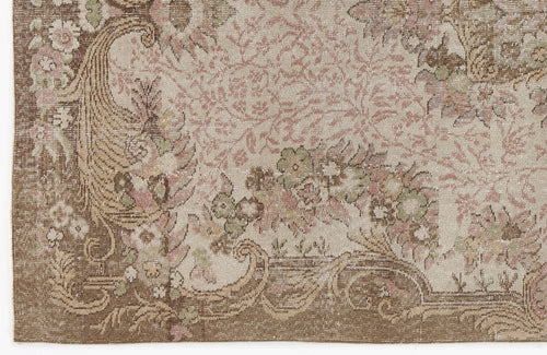 Load image 1 in gallery view. Distressed beige, brown, and muted pink rug with a traditional floral medallion and scrollwork pattern.
