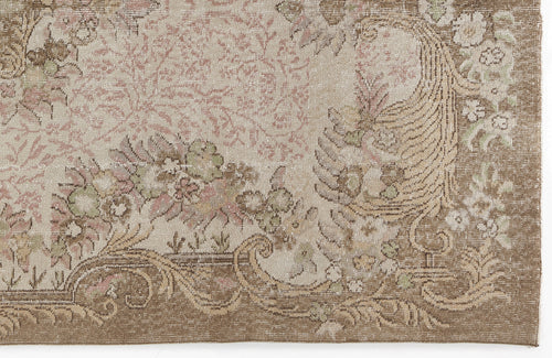 Load image 1 in gallery view. Beige and brown vintage-style rug with a faded floral medallion pattern and intricate scrollwork border.