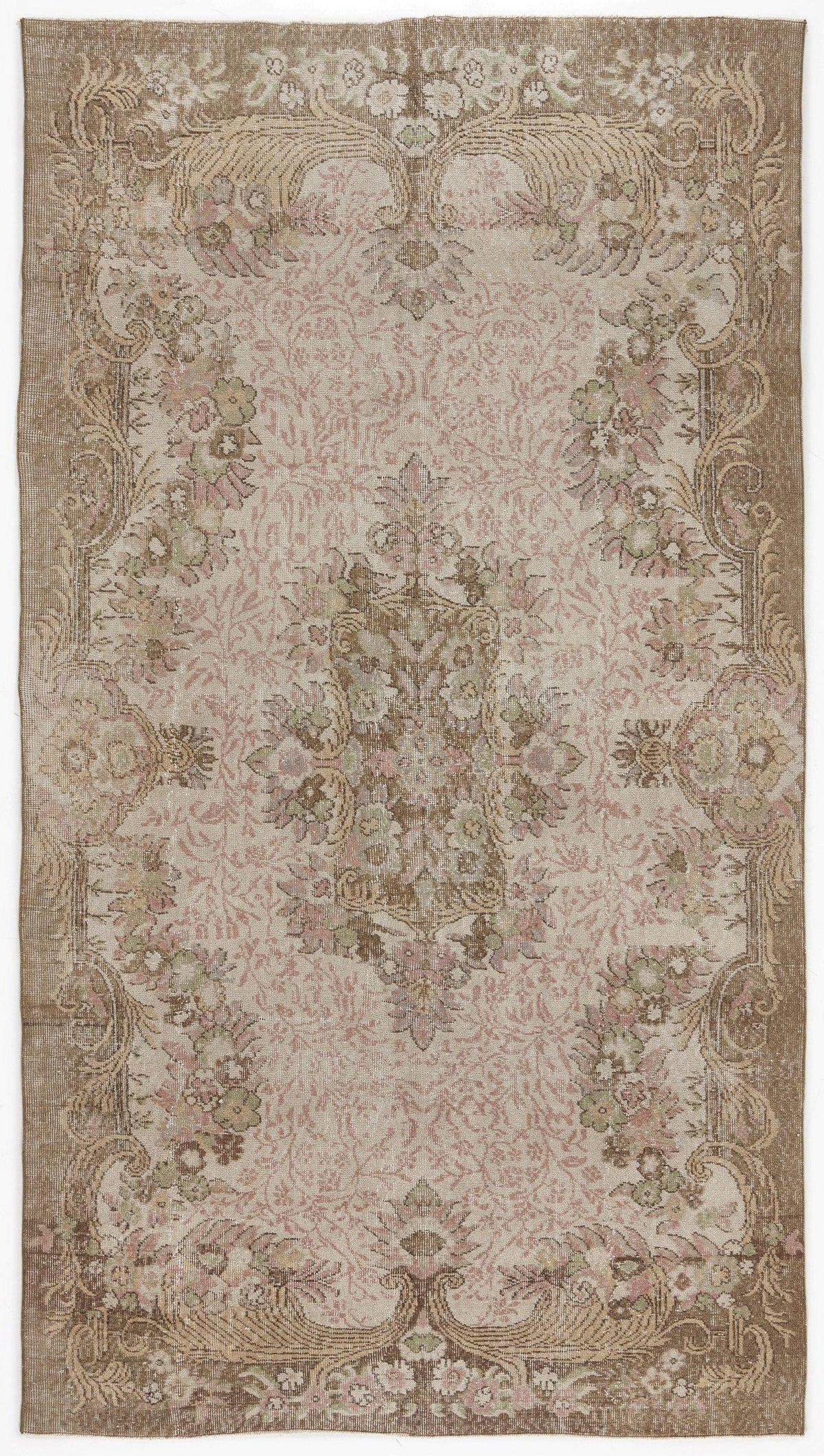 Distressed beige and pink traditional rug with a central floral medallion and ornate botanical border.