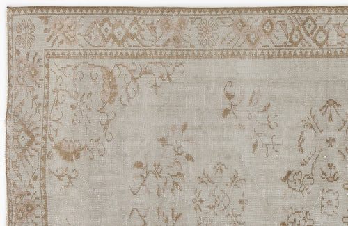 Load image 1 in gallery view. Beige and tan vintage-style rug with a faded floral border and scattered botanical motifs.
