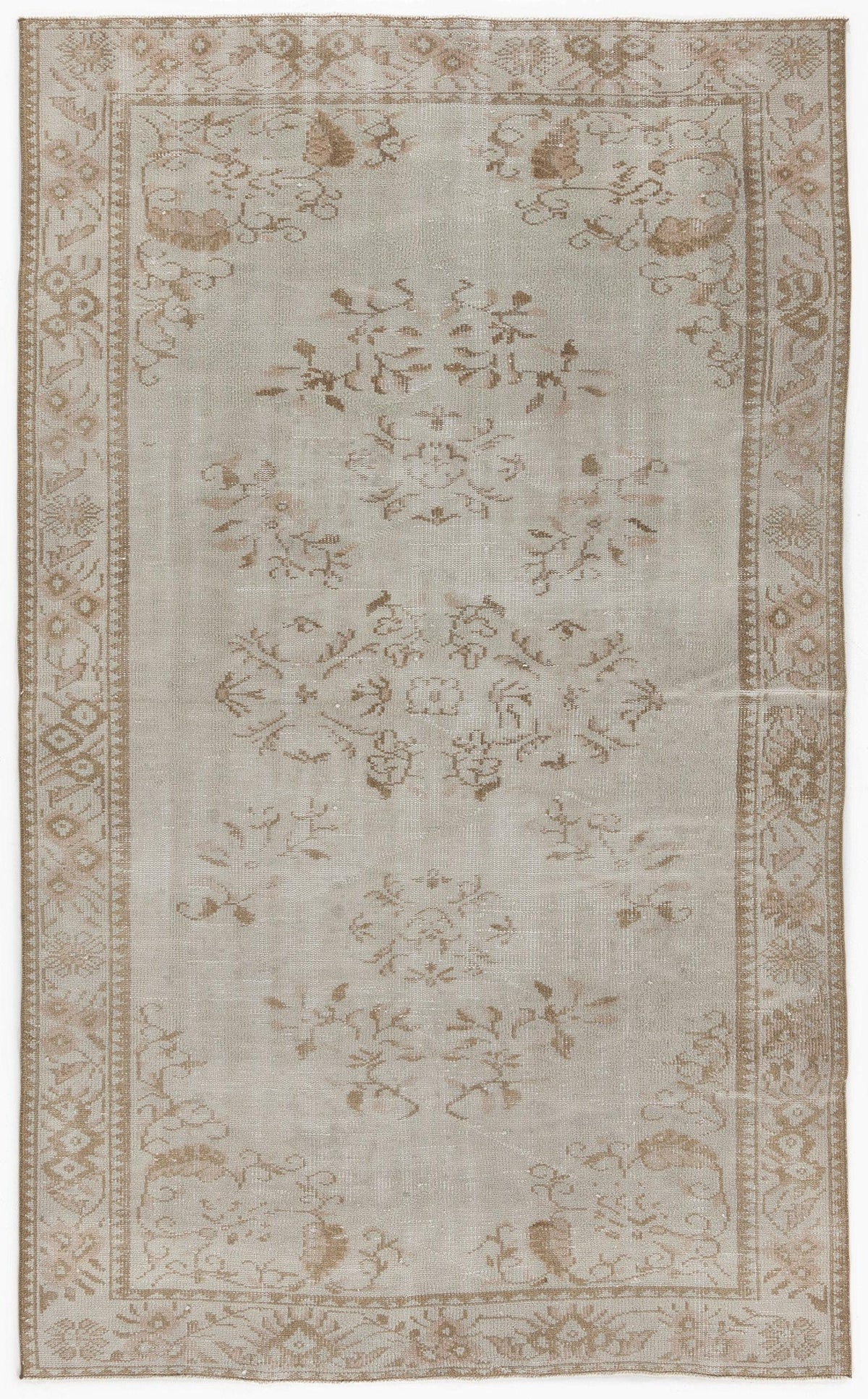 Light gray and beige vintage-style rug with a faded floral medallion pattern and a decorative border.