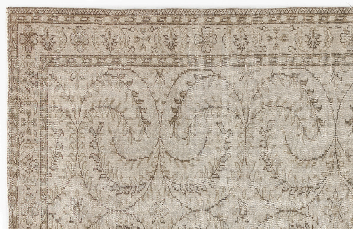 Beige and taupe rug with a distressed traditional floral vine pattern and a decorative border.