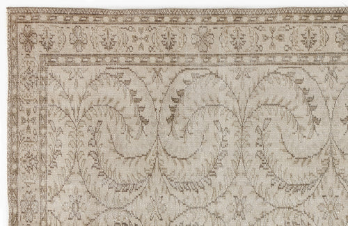 Load image 1 in gallery view. Beige and taupe rug with a distressed traditional floral vine pattern and a decorative border.
