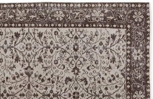 Load image 1 in gallery view. Dark brown and beige vintage-style rug with a distressed floral vine pattern and a decorative geometric border.