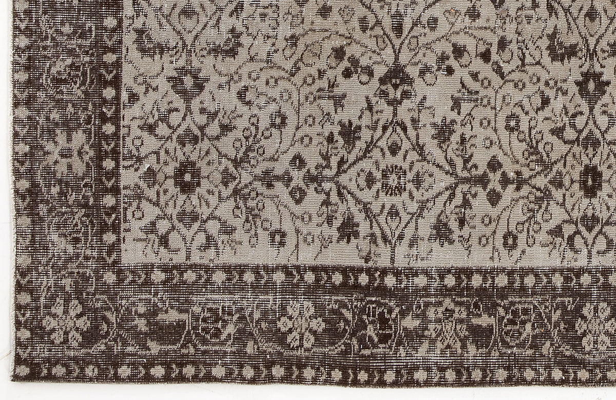 Dark brown and light gray rug with a traditional floral medallion pattern and a detailed geometric border.