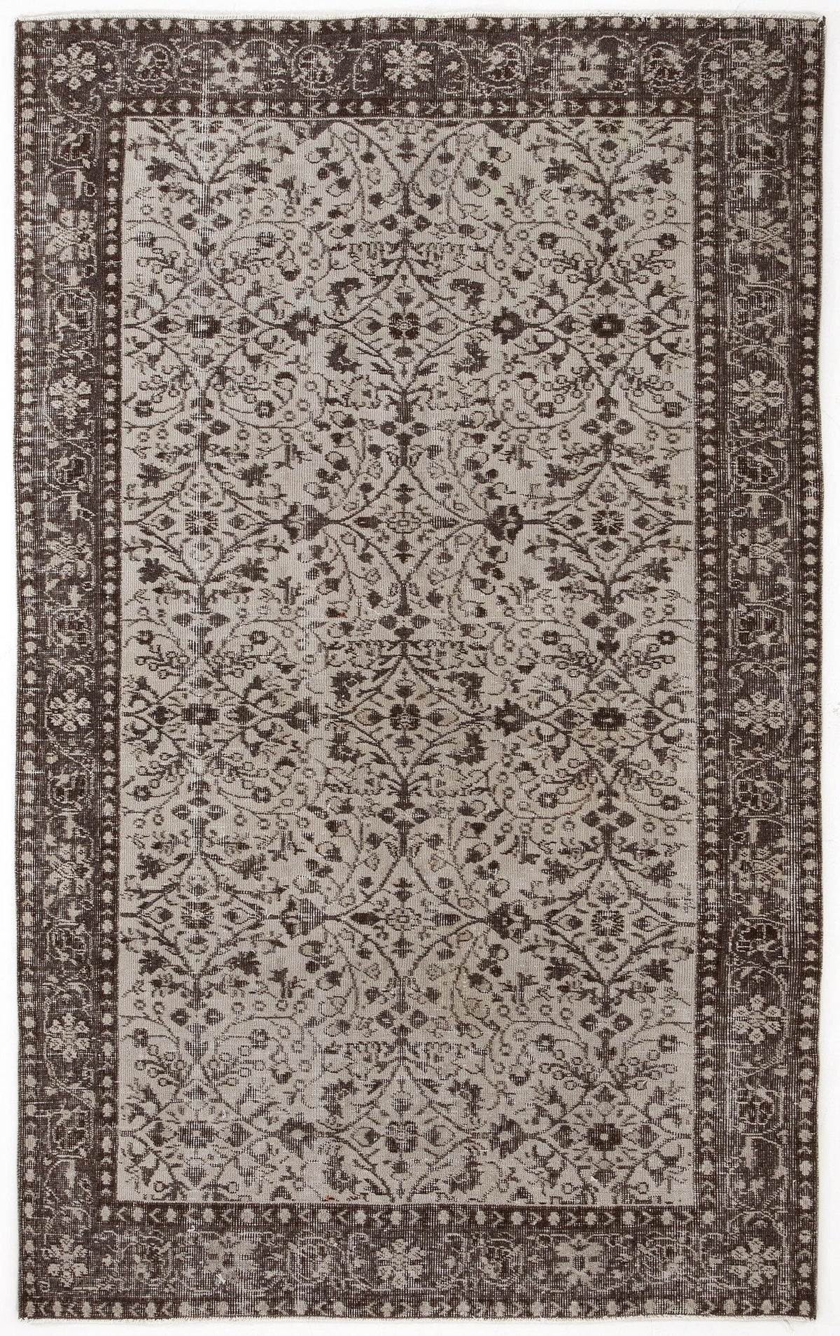 Dark brown and beige vintage-style rug with a distressed floral medallion pattern and a wide decorative border.