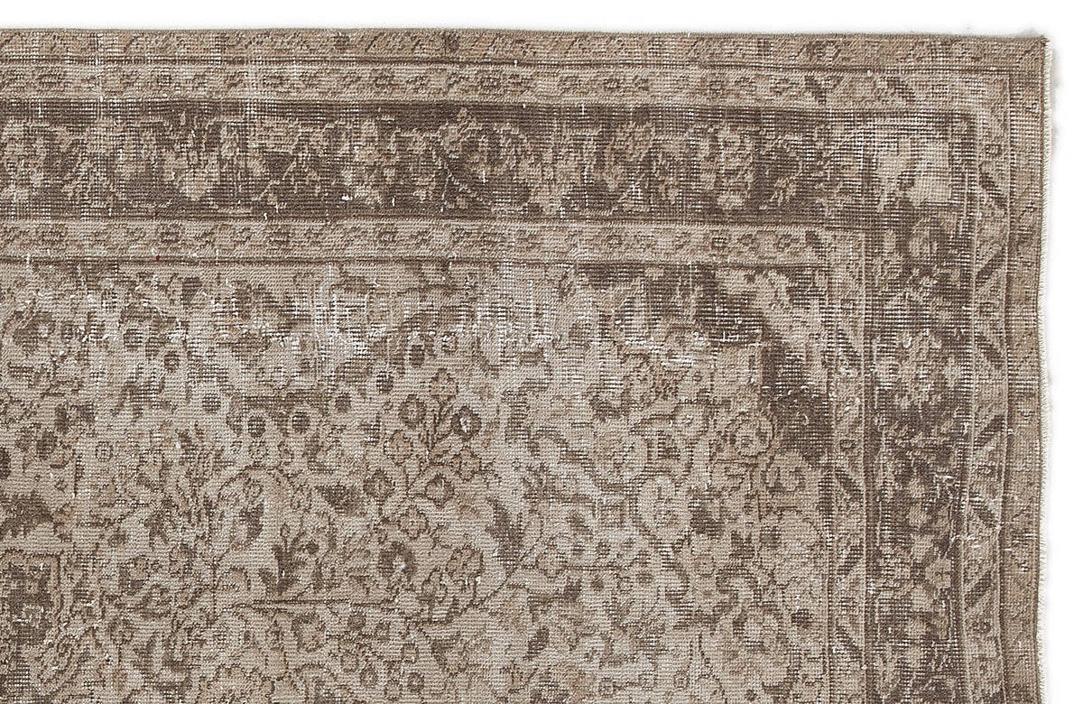Distressed brown and beige vintage-style rug with a traditional floral medallion border and intricate central pattern.