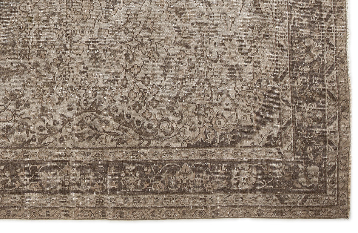 Taupe and brown vintage-style rug with a distressed floral medallion pattern and a detailed border.