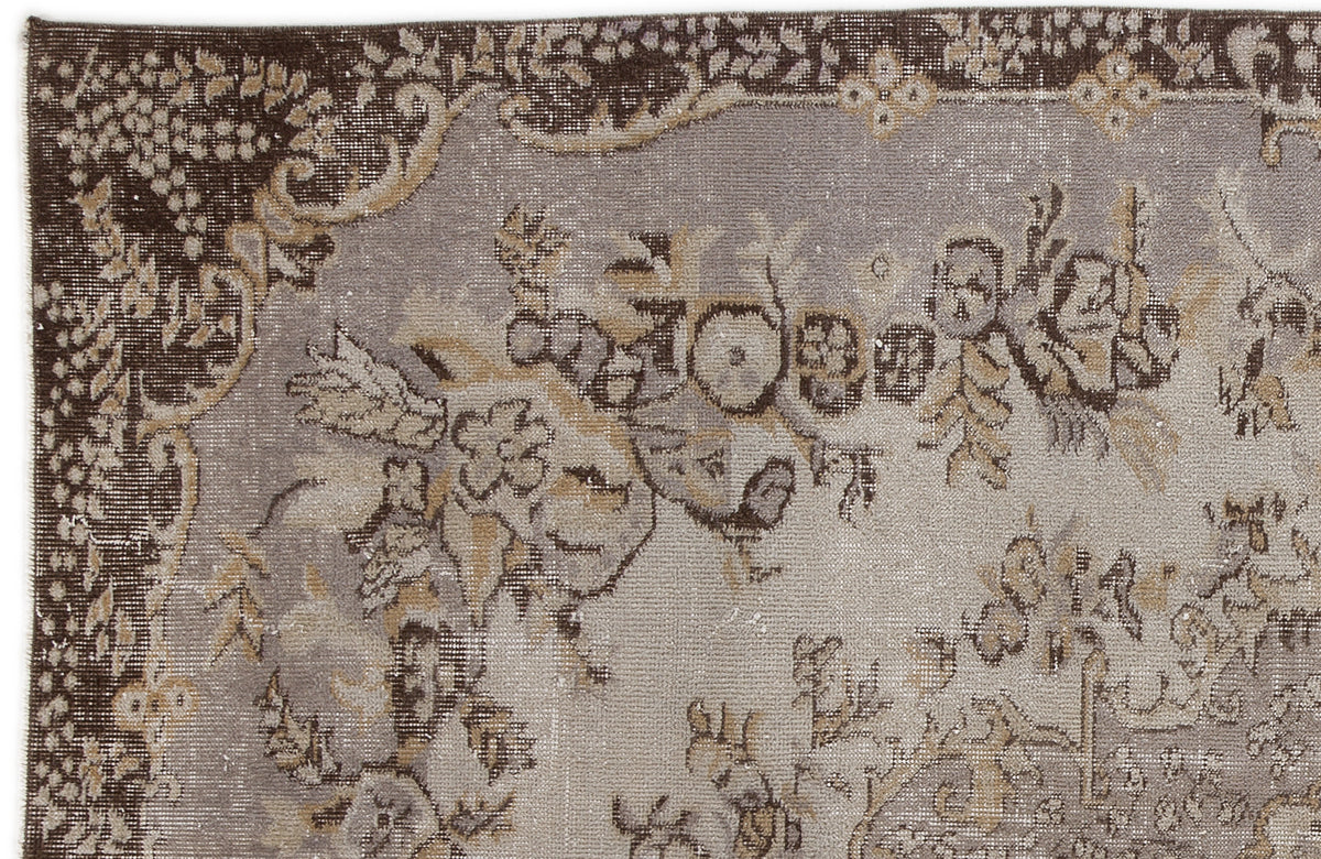 Distressed grey and brown traditional rug with a faded floral medallion pattern and ornate border.
