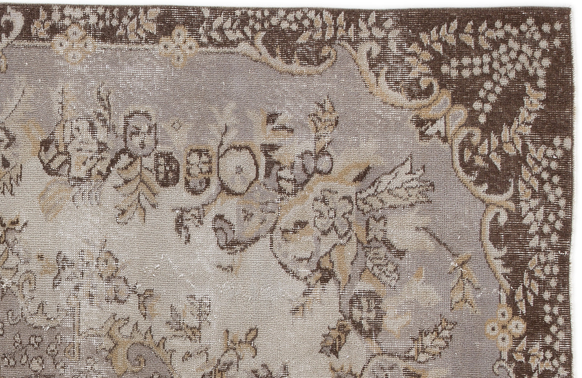 Brown and grey vintage-style rug with a distressed floral medallion pattern and ornate border.