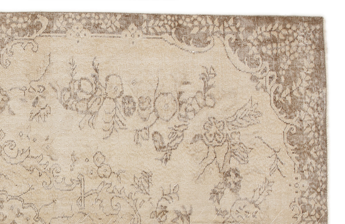 Beige and brown rug with a faded, distressed floral medallion pattern on a white background.