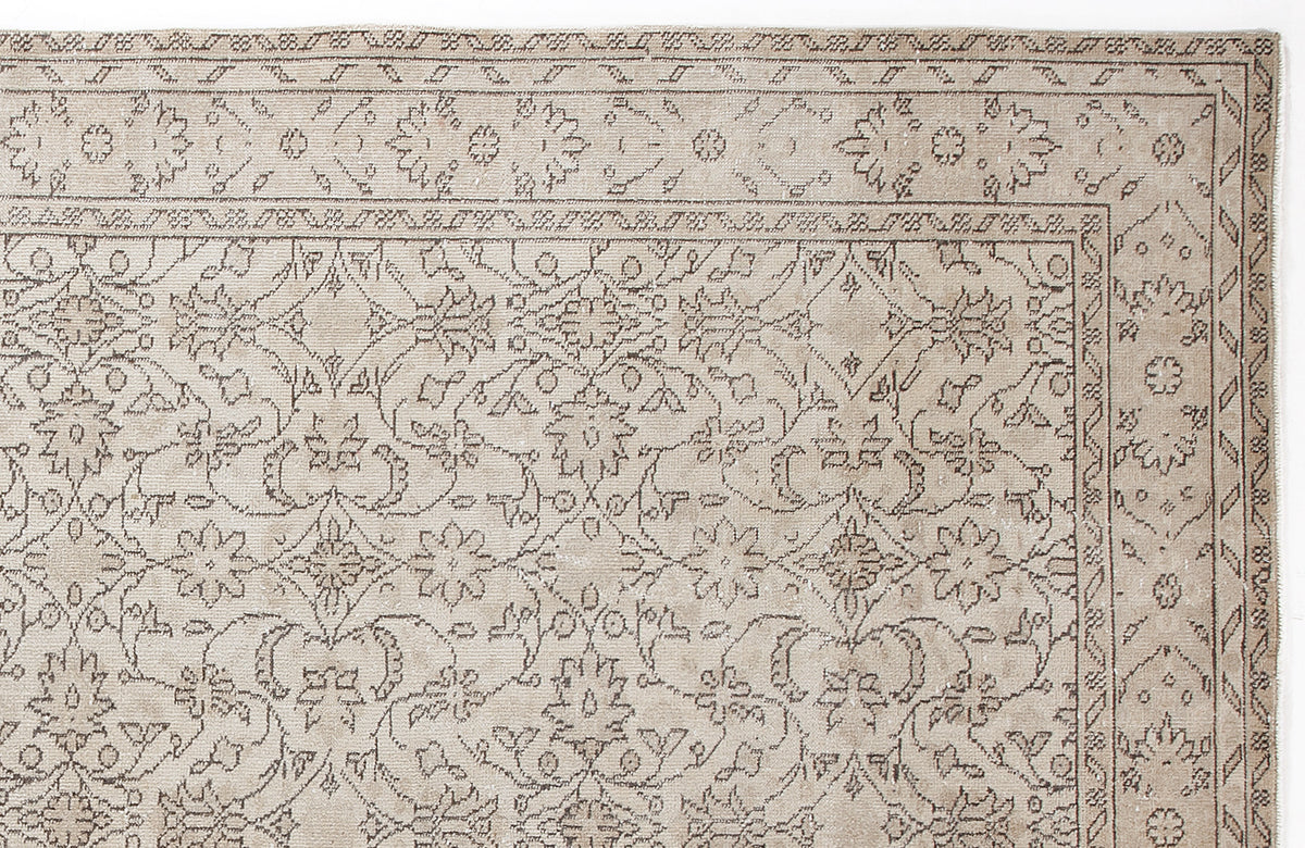 Beige rug with a dark brown traditional floral medallion pattern and a decorative geometric border.