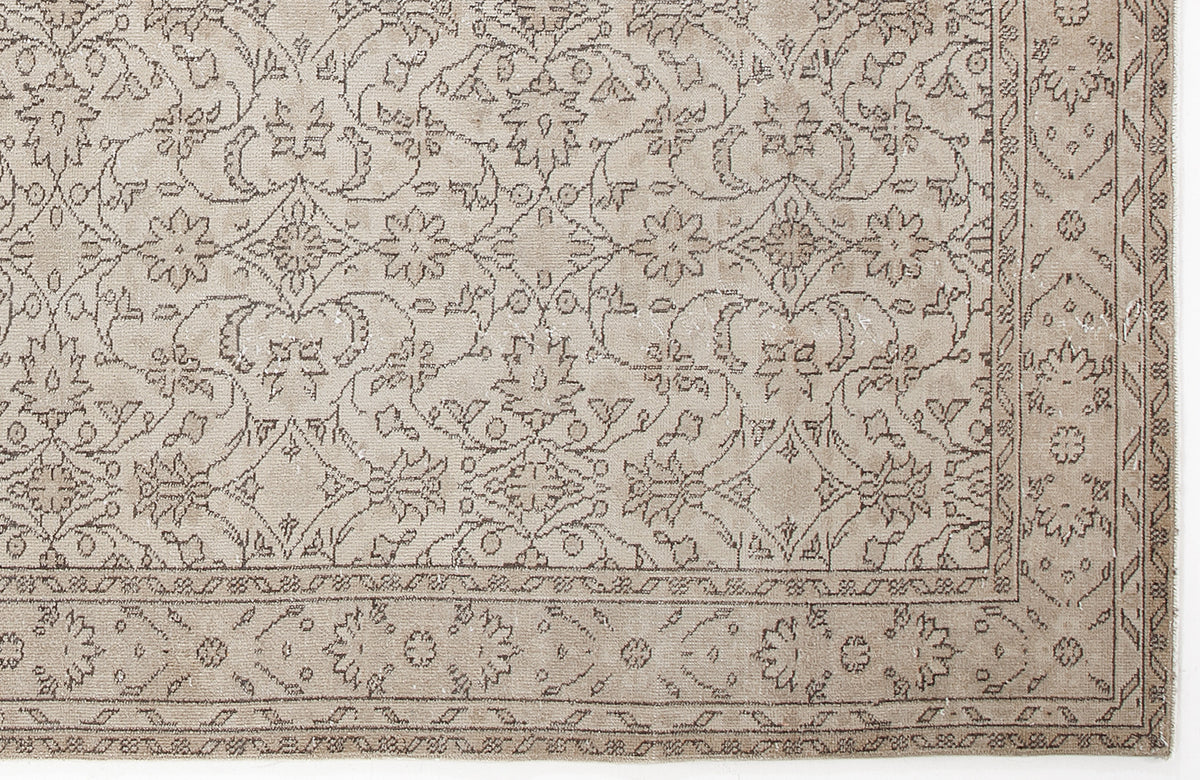 Beige rug with a dark brown traditional floral medallion pattern and a decorative border.