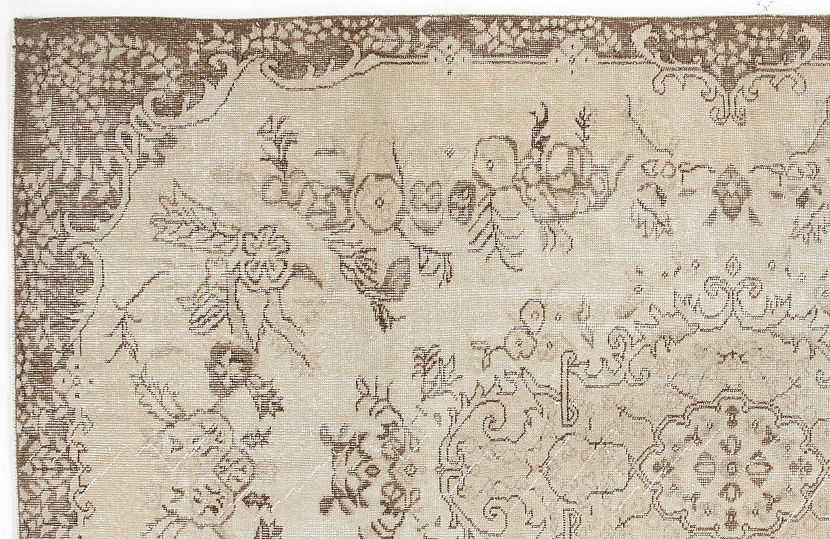 Beige and brown vintage-style rug with a distressed floral medallion pattern and ornate border.
