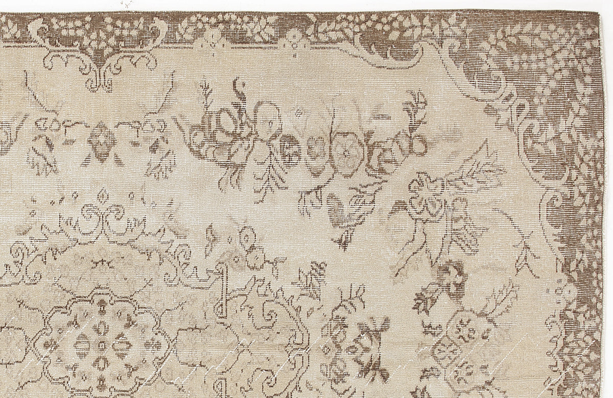 Beige and brown traditional rug with a distressed floral medallion pattern on a white background.