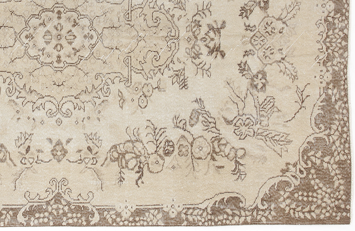 Beige and brown vintage-style rug with a distressed floral medallion pattern and ornate border.