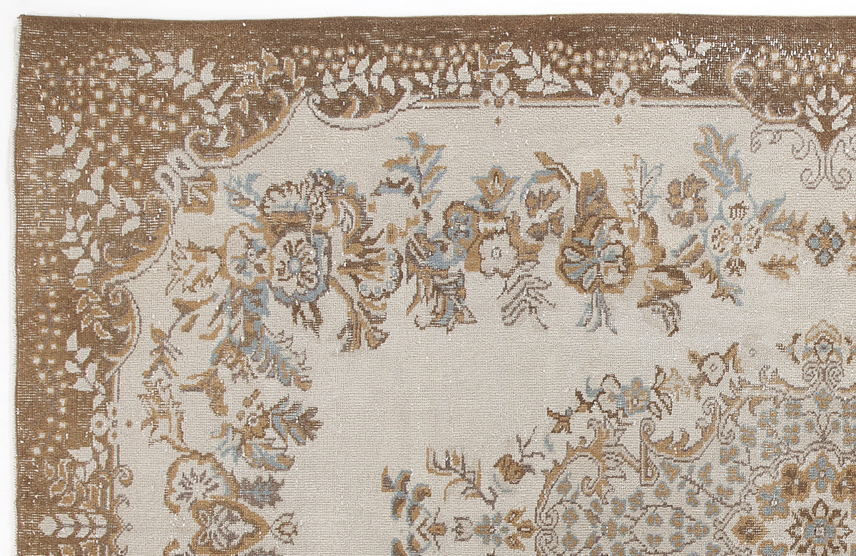 Beige and brown distressed rug with a floral medallion pattern and light blue accents.