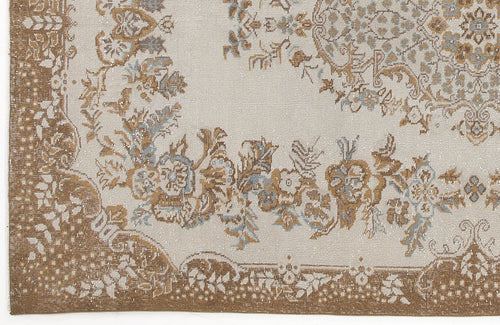 Load image 1 in gallery view. Beige rug with a distressed floral medallion pattern in shades of brown and light blue.