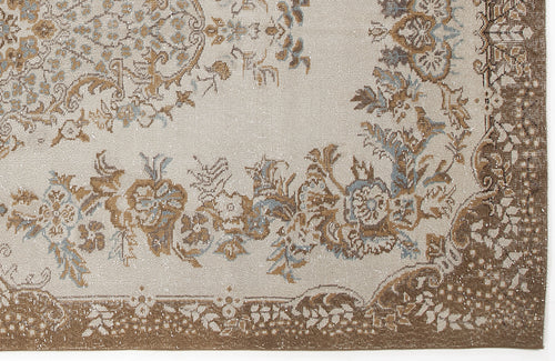 Load image 1 in gallery view. Beige rug with a distressed floral medallion pattern in brown and slate blue, featuring a wide decorative border.