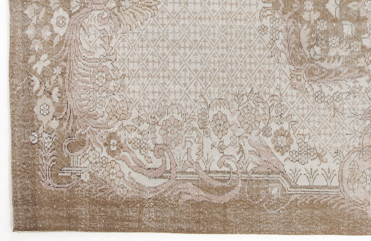 Taupe and cream rug with a distressed floral medallion pattern and a central diamond lattice motif.