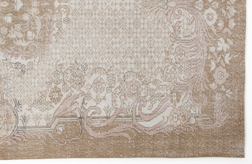 Load image 1 in gallery view. Beige and cream rug with a distressed floral medallion pattern and a geometric lattice border.