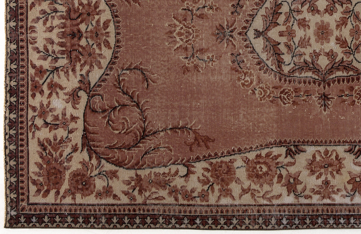 Terracotta and beige traditional rug with a distressed floral medallion pattern and a detailed geometric border.