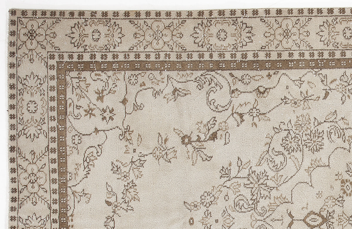 Beige and brown traditional rug with a floral vine pattern and a decorative border.