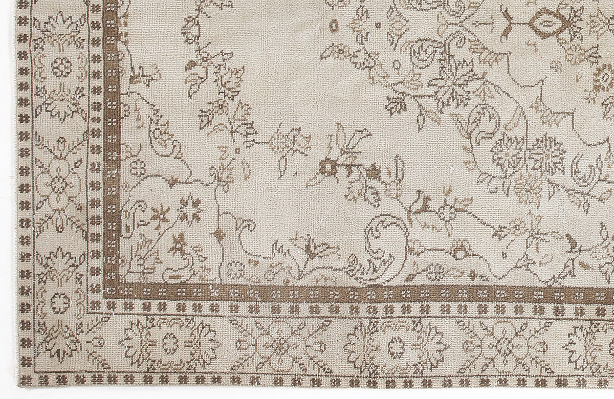 Beige and taupe rug with a traditional floral medallion pattern and a geometric border.