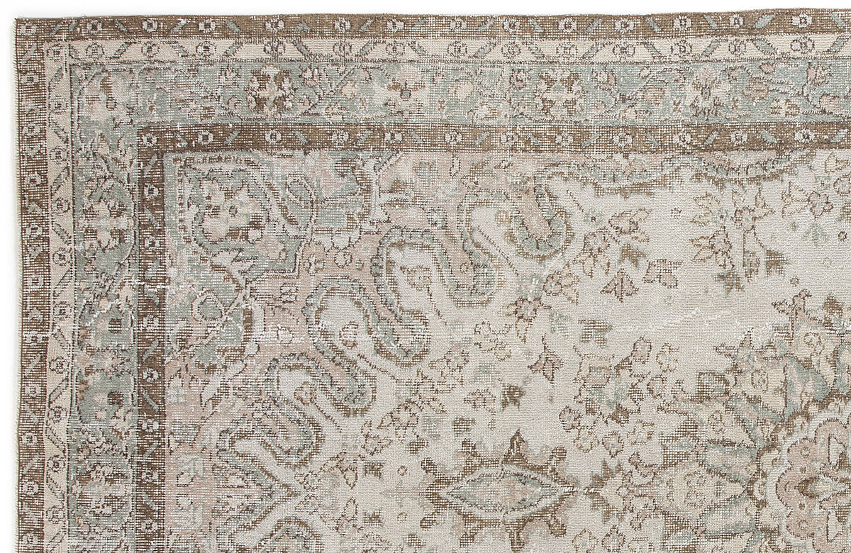 Distressed beige and sage green rug with a traditional floral medallion border and intricate vine patterns.