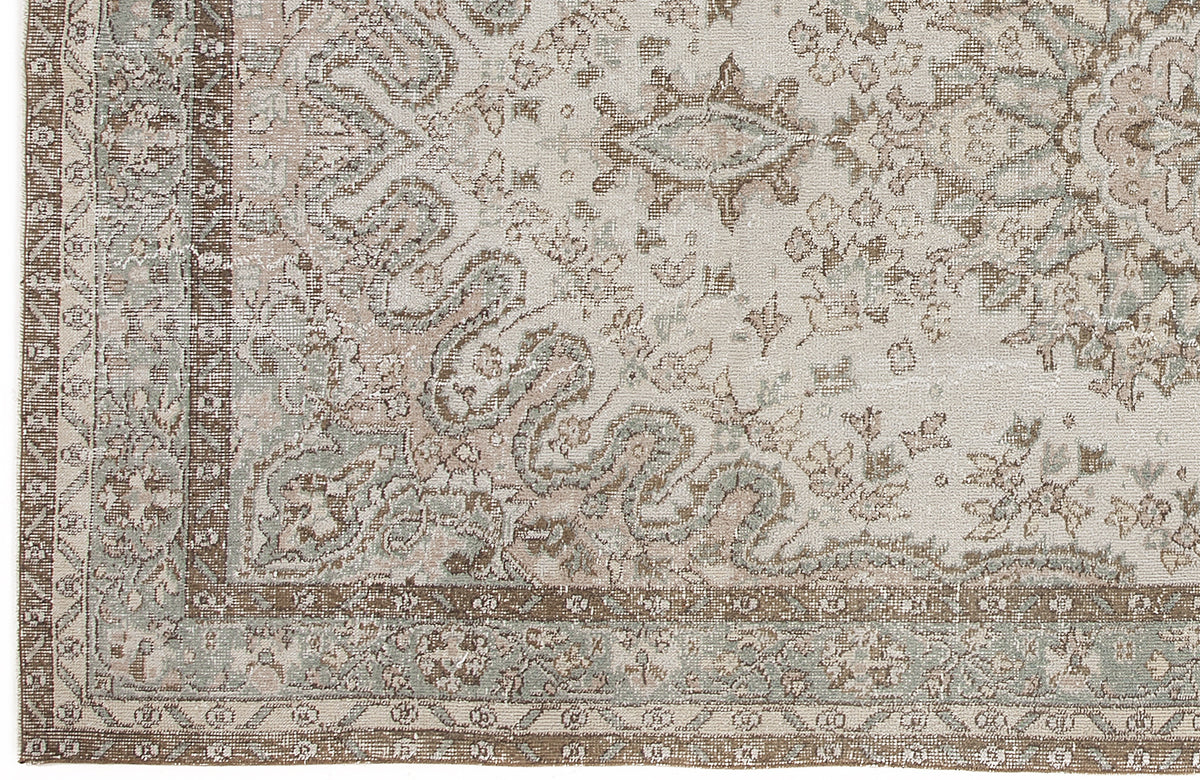 Distressed beige, brown, and sage green rug with a traditional ornate medallion pattern and a detailed geometric border.