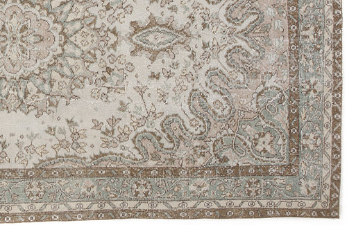 Load image 1 in gallery view. Distressed traditional rug with a cream, sage green, and brown floral medallion pattern and a detailed border.