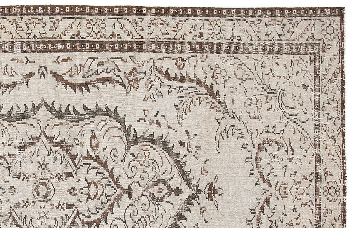 Beige and brown traditional rug with a distressed floral medallion pattern and a geometric border.