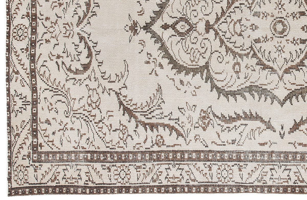 Cream and brown rug with a distressed traditional medallion pattern and a geometric border.