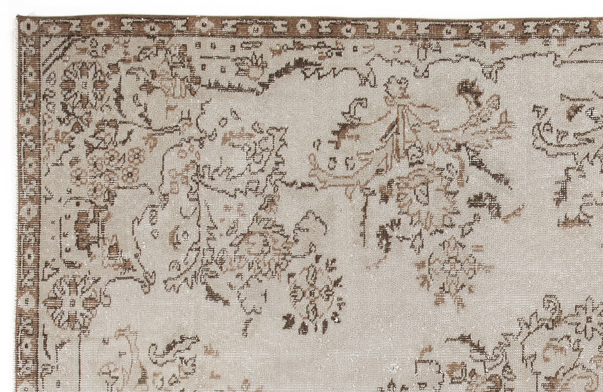 Beige and brown rug with a distressed traditional floral medallion pattern and a decorative border.