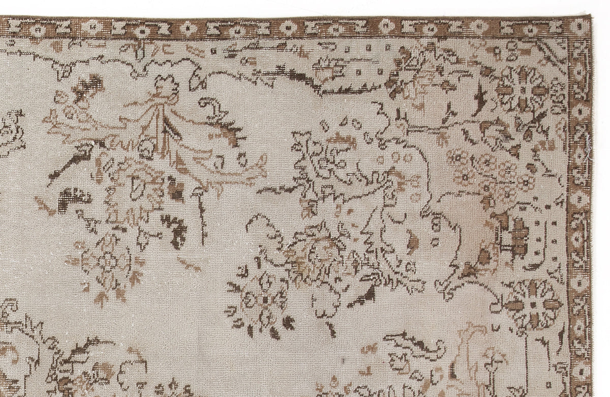 Beige and brown vintage-style rug with a distressed floral medallion pattern and a geometric border.