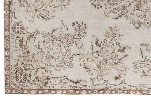 Load image 1 in gallery view. Beige and brown distressed rug with a faded floral medallion pattern and a geometric border.
