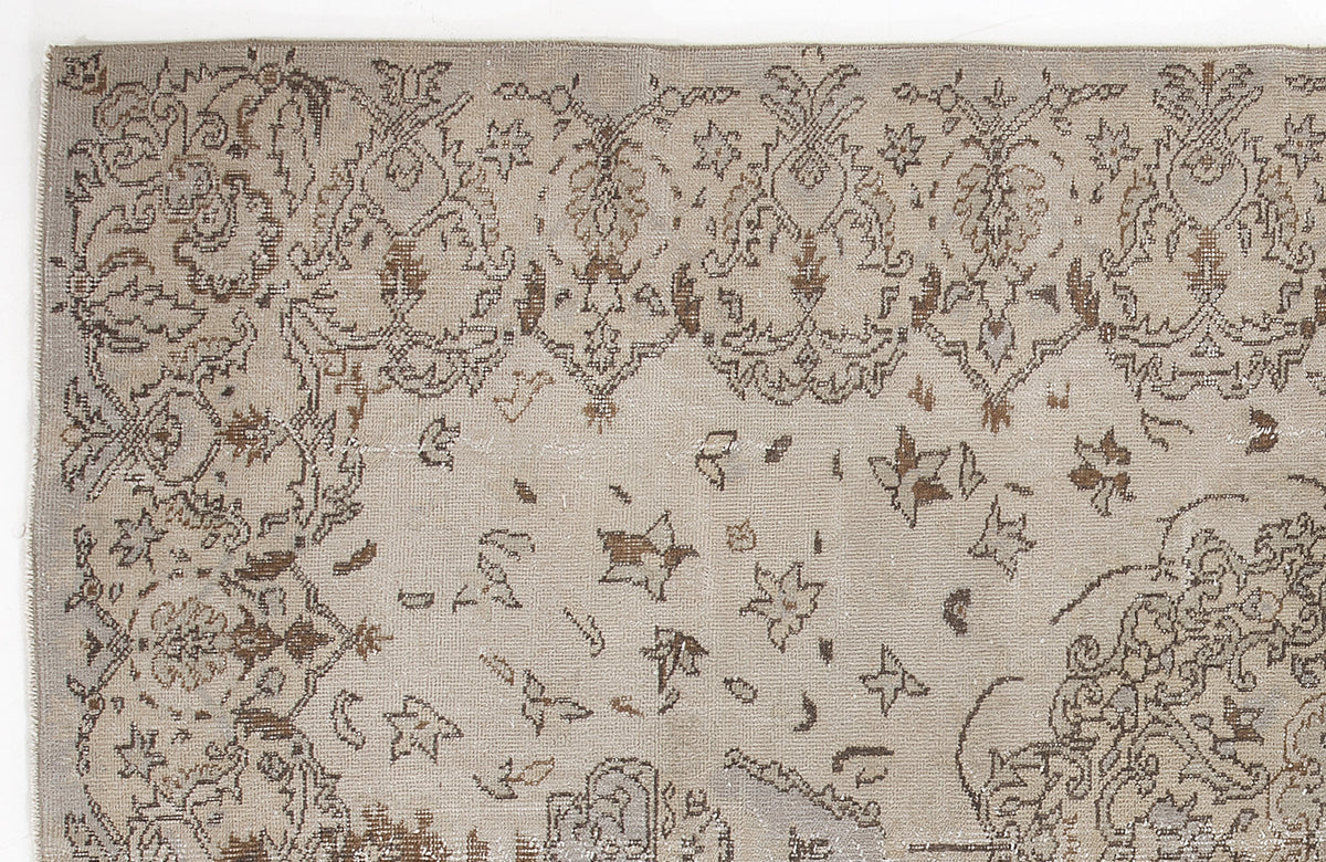 Taupe and brown vintage-style rug with a distressed floral medallion pattern on a white background.