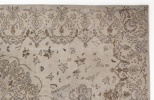 Load image 1 in gallery view. Taupe and brown distressed rug with a traditional floral medallion pattern and scattered botanical motifs.